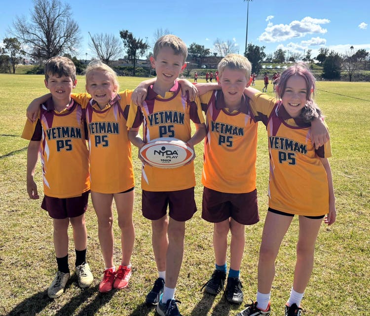 A photo of five students with a football in the Yetman footy singlets